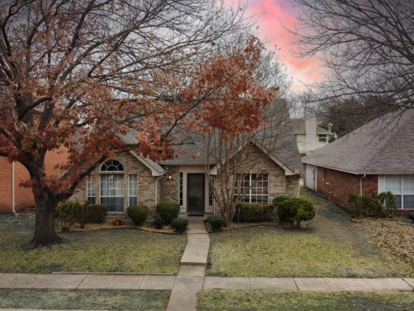 This inviting two-story home in Allen, TX, is framed by mature trees and classic brick architecture, offering a warm and welcoming first impression. A paved walkway leads to the covered front entrance, flanked by manicured shrubs and a lovely arched window that enhances the home's character. Nestled in the desirable Cottonwood Bend (North) community and within the top-rated Allen ISD, this home combines charm with convenience, providing easy access to local parks, schools, and shopping.