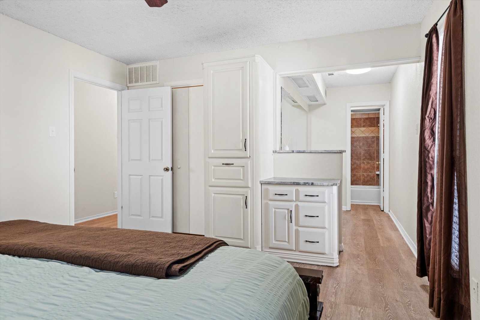 21-1613 St James Dr-21 Primary bedroom with built-in cabinetry, walk-in closet access, and ensuite bath at 1613 Saint James Drive.