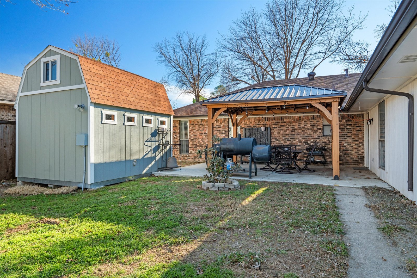 24-1613 St James Dr-24 Backyard patio with pergola for cover and climate-controlled bonus shed with electricity at 1613 Saint James Drive.