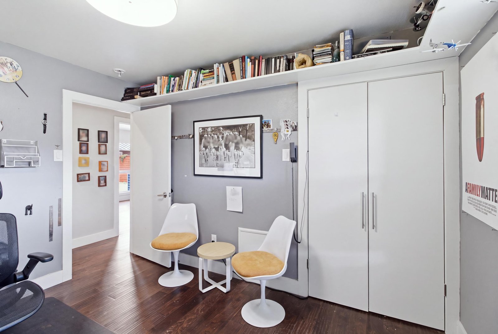 23_img_0104_reedit_db113767 Another perspective of the secondary bedroom currently used as a home office, highlighting the double-door closet, extensive upper-wall shelving, and room for additional seating. The versatile layout offers flexibility for a bedroom, home office, or personal retreat.