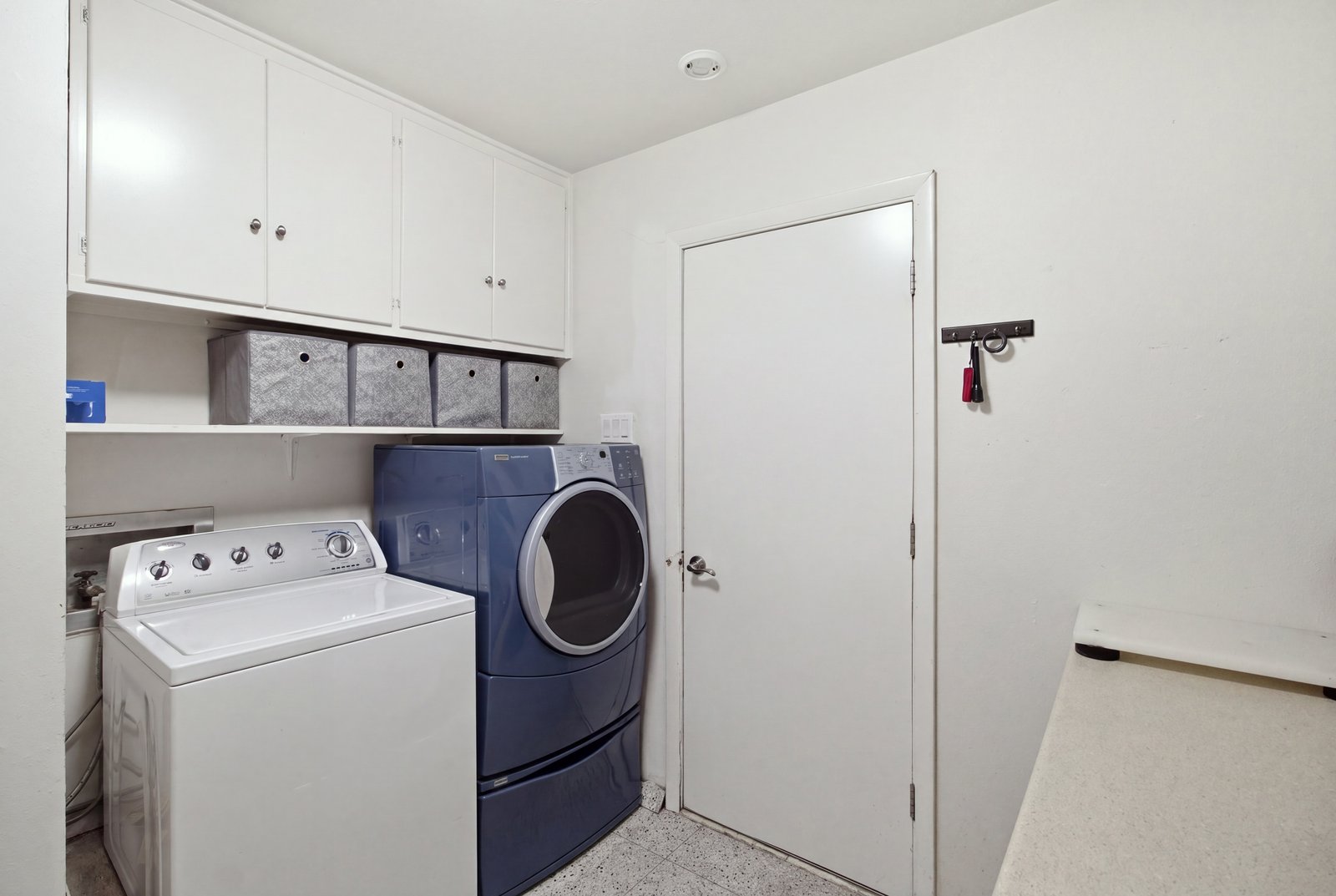 47_img_9977_reedit_31eec947_autoremove_67816888 Conveniently located just off the kitchen, the dedicated laundry room offers space for a full-size washer and dryer, overhead cabinetry, open shelving, and additional counter space for folding clothes or organizing household essentials.