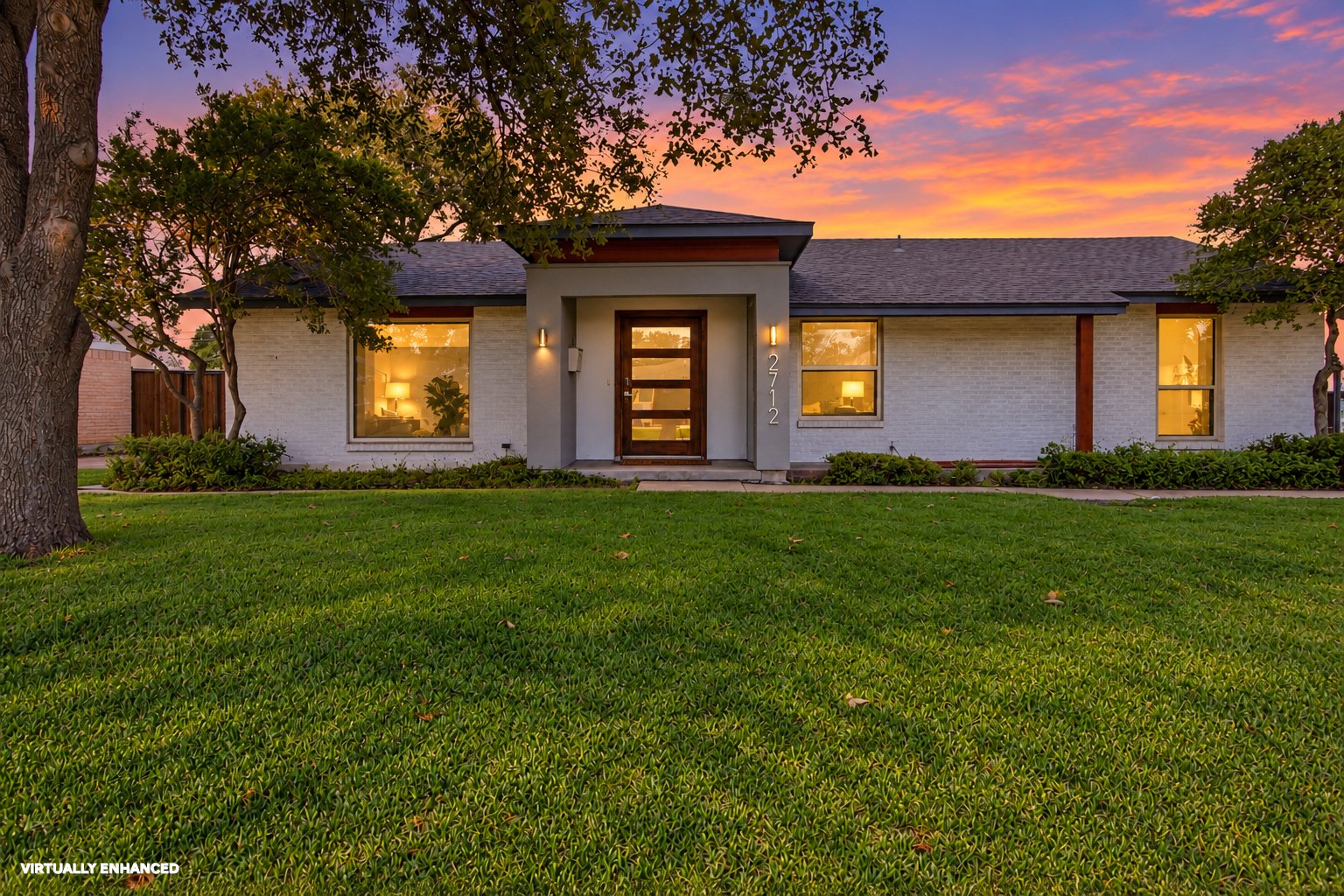 Welcome to 2712 Beechmont Place, where contemporary updates and mid-century modern influences meet the charm of an established neighborhood. A white brick exterior, distinctive modern entryway, and warm architectural lighting create an inviting first impression. Mature trees, an expansive front lawn, and thoughtfully arranged landscaping complement the home's clean lines and attractive single-story design.